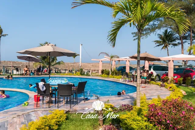 Mesas con sombrilla a la orilla de la alberca exterior · Hotel Casa del Mar